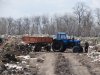 Трактор вываливающий мусор, разворачивается 